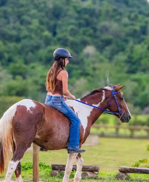A girl riding a brown and white horse at The Stables at Sleeping Giant.