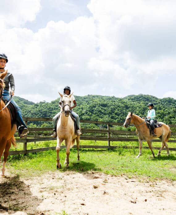 A group of kids riding horses in the corral at The Stables at Sleeping Giant.