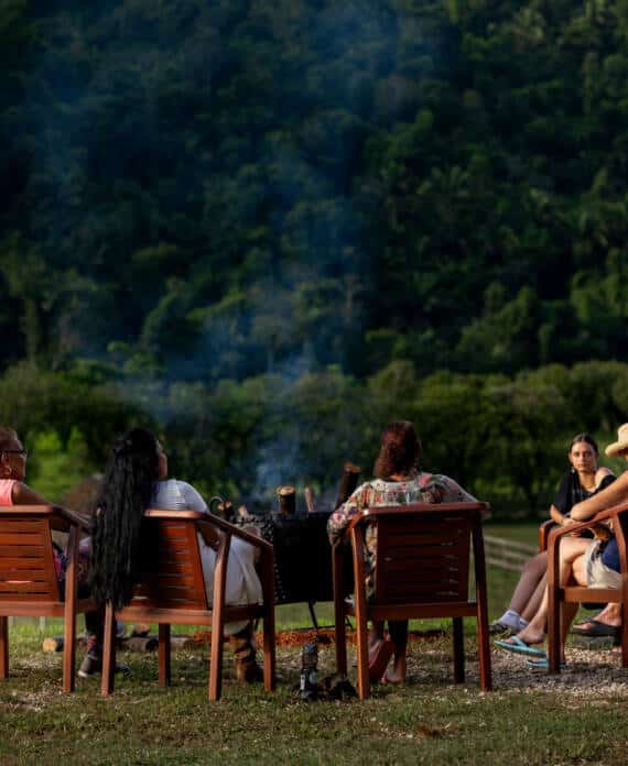 A group of women gathered by the campfire at The Stables at Sleeping Giant.