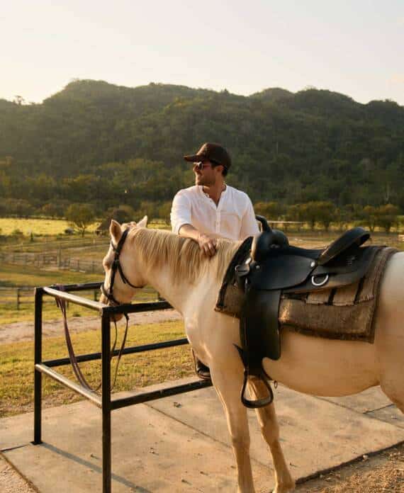 A man standing beside a white horse at The Stables at Sleeping Giant.